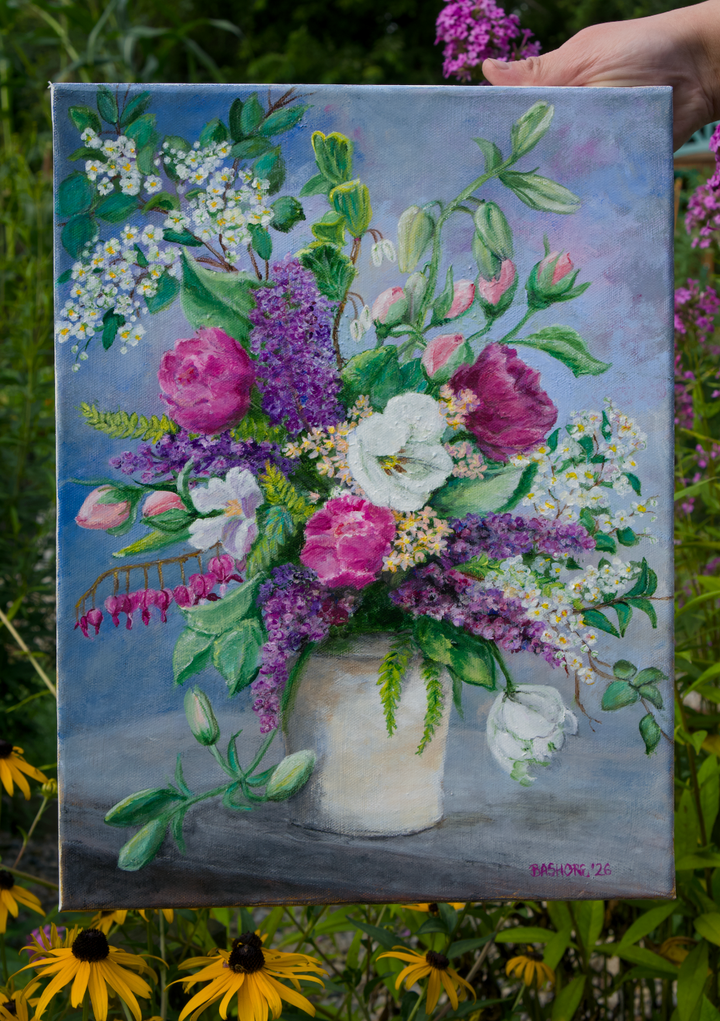 A square canvas painting of a vibrant flower bouquet in a white vase, held by a hand against a background of green foliage and yellow flowers. The painting features purple, pink, and white flowers with green leaves on a soft blue-gray background.